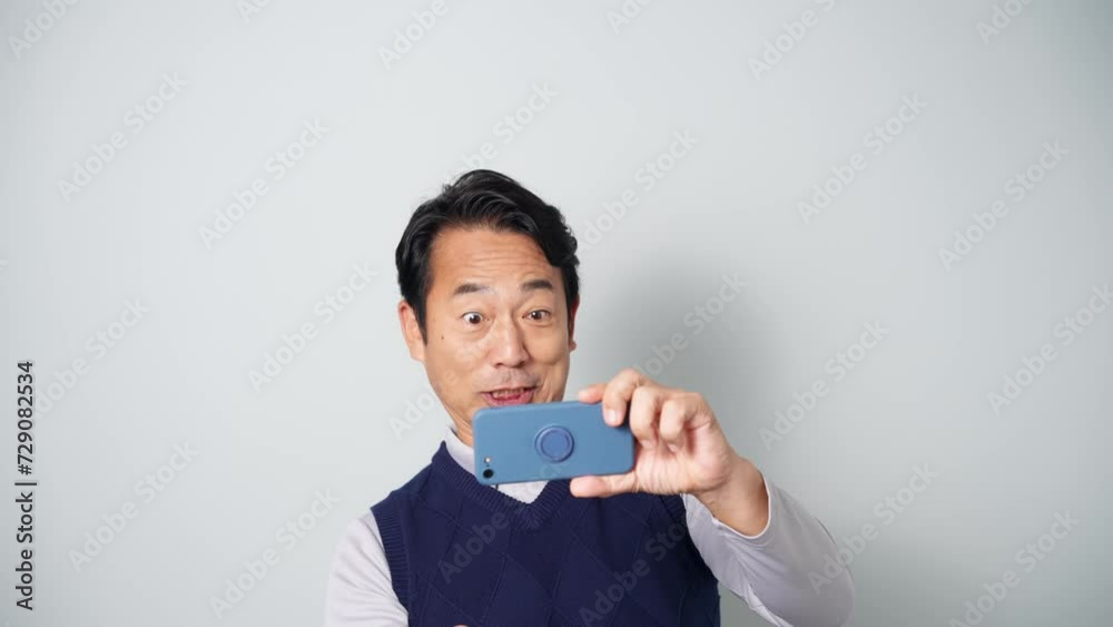 スマホを見て興奮するミドル男性 スマホを見て興奮するミドル男性