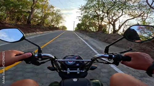 A Man's POV riding a motorbike into the sunset, Ometepe island, Nicragua photo