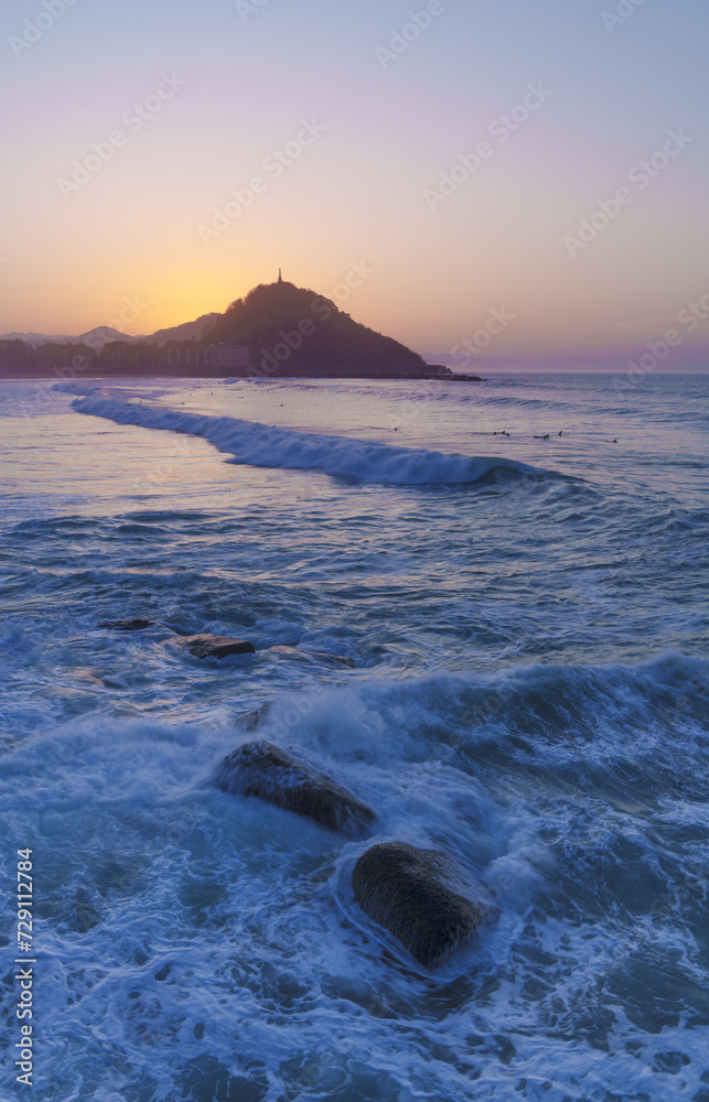 Naklejka premium Sunset at Zurriola beach. Sunset on Mount Urgull and Zurriola beach, City of Donostia San Sebastian.