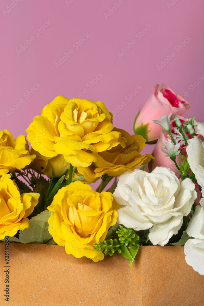 Beautiful bouquet of yellow and white roses on a pink background. close-up Beautiful bouquet of yellow and white roses on a pink background. close-up