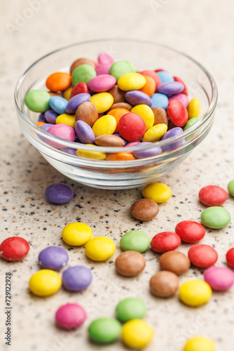 Colorful sweet candies in bowl on kitchen table.