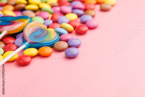 Colorful sweet jelly candies and lollipops. Sweet candies on pink background.