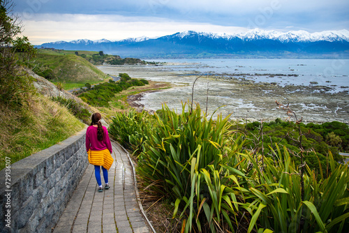 hiker girl enjoying a walk on kaikoura coast track in canterbury, new zealand; scenic track on famous peninsula with fur seal colony photo