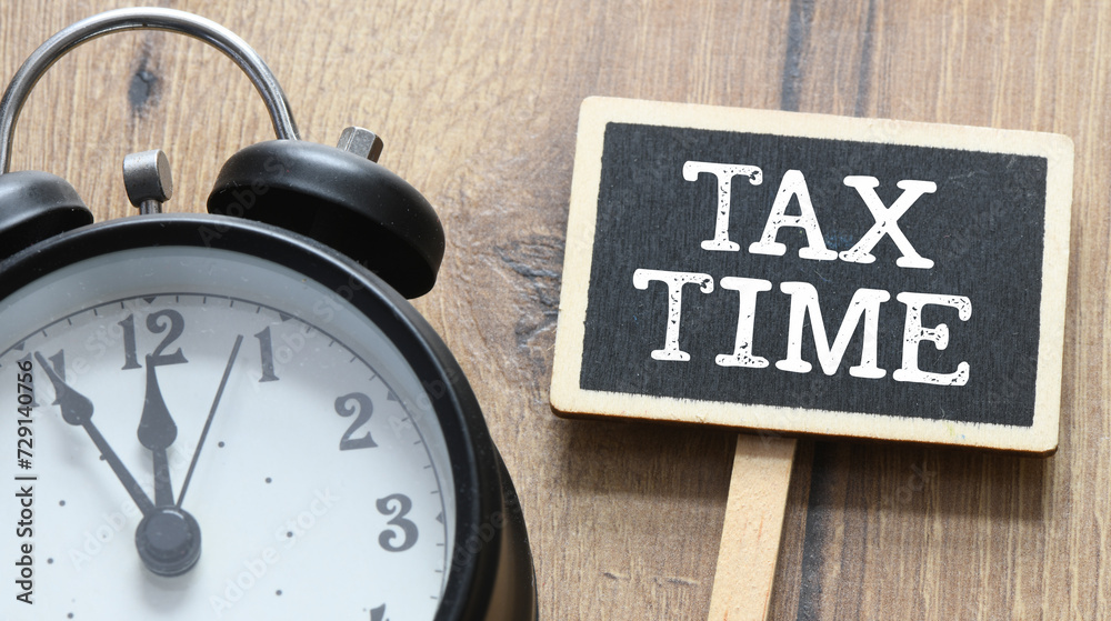 TAX TIME - words on a small chalk board. Concept for business. TAX TIME - words on a small chalk board. Concept for business.