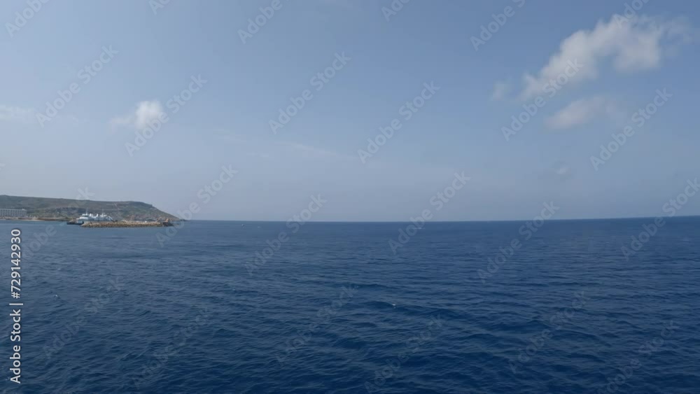 Sailing on calm Mediterranean sea with a clear sky ahead, Mgaar port on the horizon. Sailing on calm Mediterranean sea with a clear sky ahead, Mgaar port on the horizon.