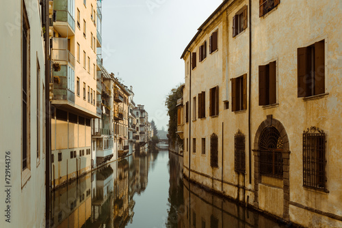 The city canal San Massimo in Padua. Beautiful urban view of residential buildings with balconies in the center of the old city Padova, Veneto. Rivers Brenta and Bacchiglione, Italy