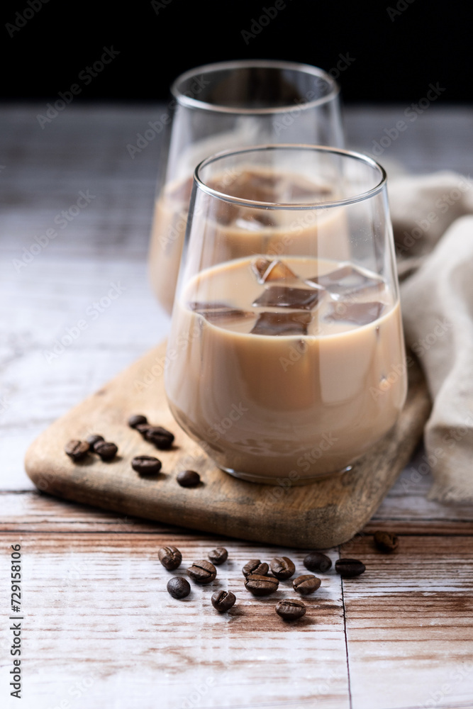 Traditional Irish cream coffee liqueur with ice on wooden table Traditional Irish cream coffee liqueur with ice on wooden table