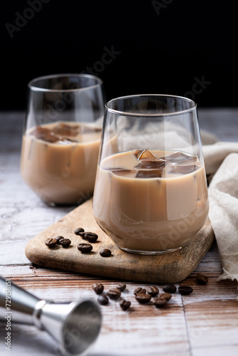 Traditional Irish cream coffee liqueur with ice on wooden table