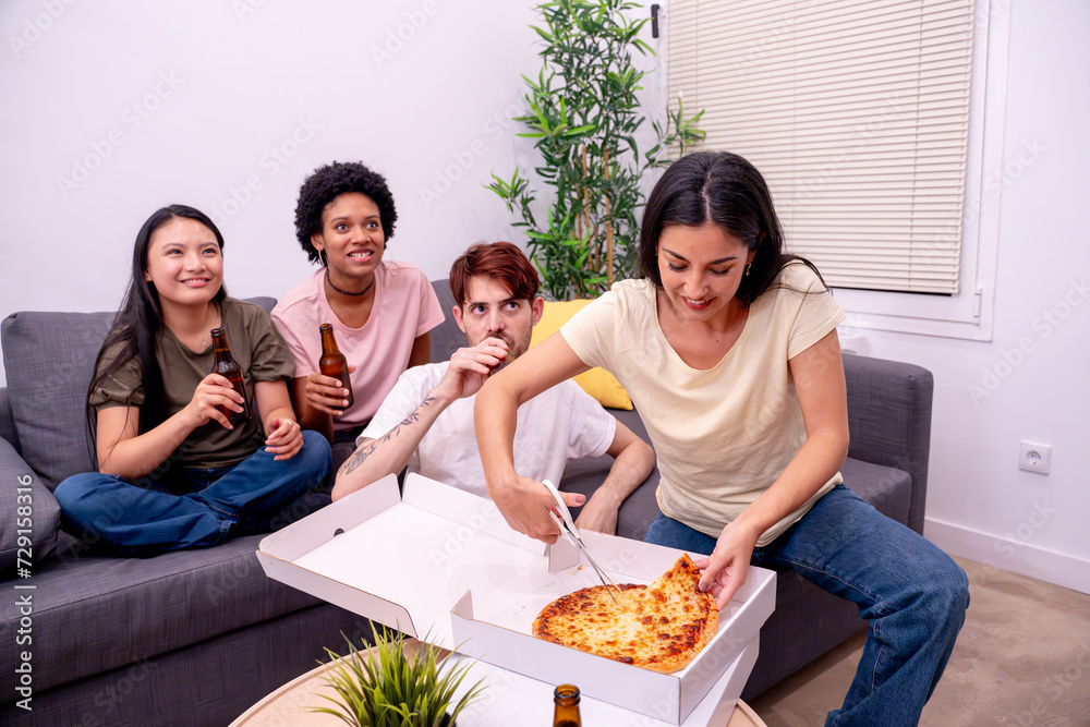 Group of four friends enjoying pizza and beers in a comfortable living room with a houseplant. 