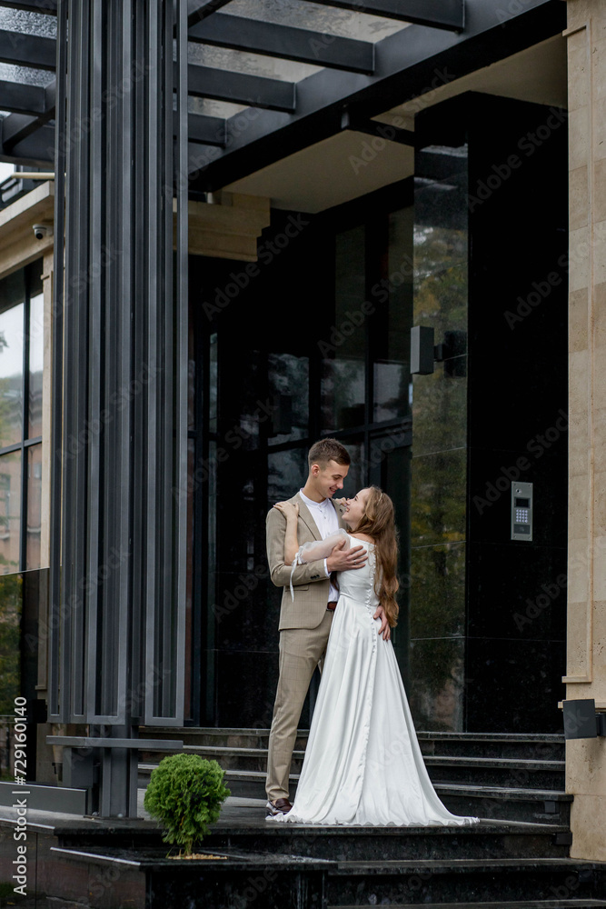 Fototapeta premium Smiling bride and groom, romantic embracing at their wedding day