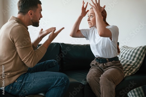 Fotografija Side view of couple that are arguing. Sitting on sofa