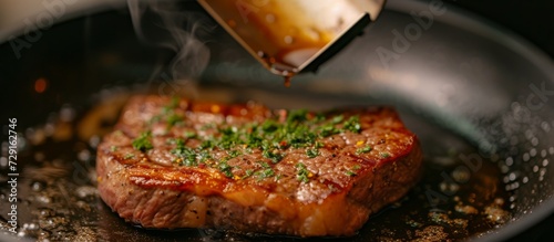 Close-up shot of a golden brown, medium well steak being flipped with a frying shovel in a pan.