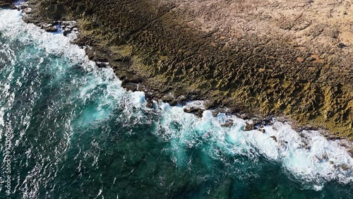 Breccia rock formation tendrils from eroded water as waves crash on Northside Curacao shore, aerial photo