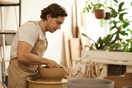 Pottery maker shaping a bowl on a wheel with his hands