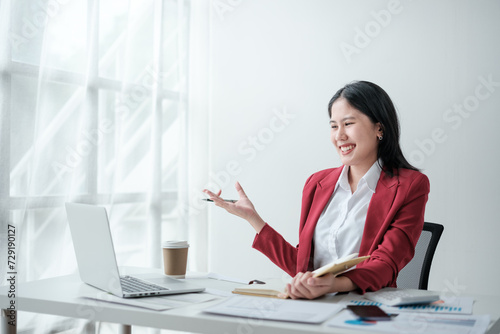 Portrait of smile beautiful business asian woman in red suit working office desk computer. Small business sme .