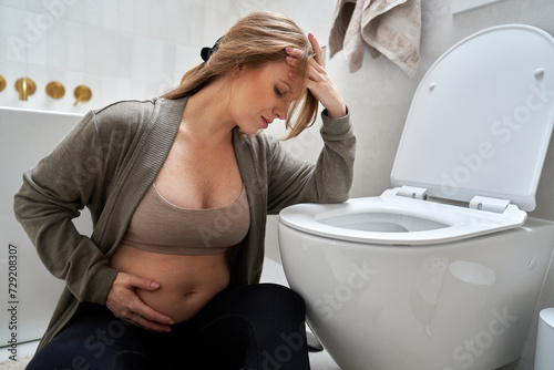 Pregnant woman having morning sickness photo