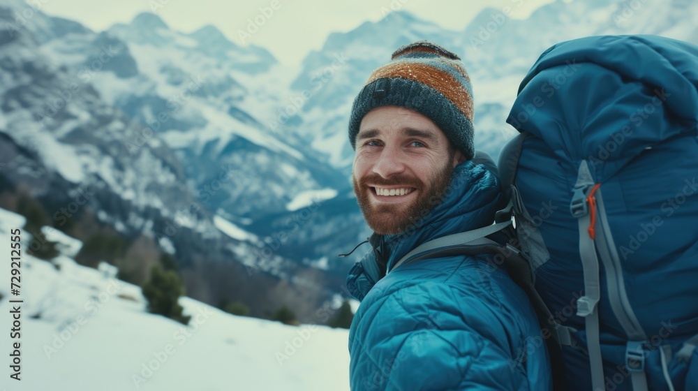 A man with a backpack is pictured standing on a snowy mountain. This image can be used to depict outdoor adventure, hiking, or winter landscapes A man with a backpack is pictured standing on a snowy mountain. This image can be used to depict outdoor adventure, hiking, or winter landscapes