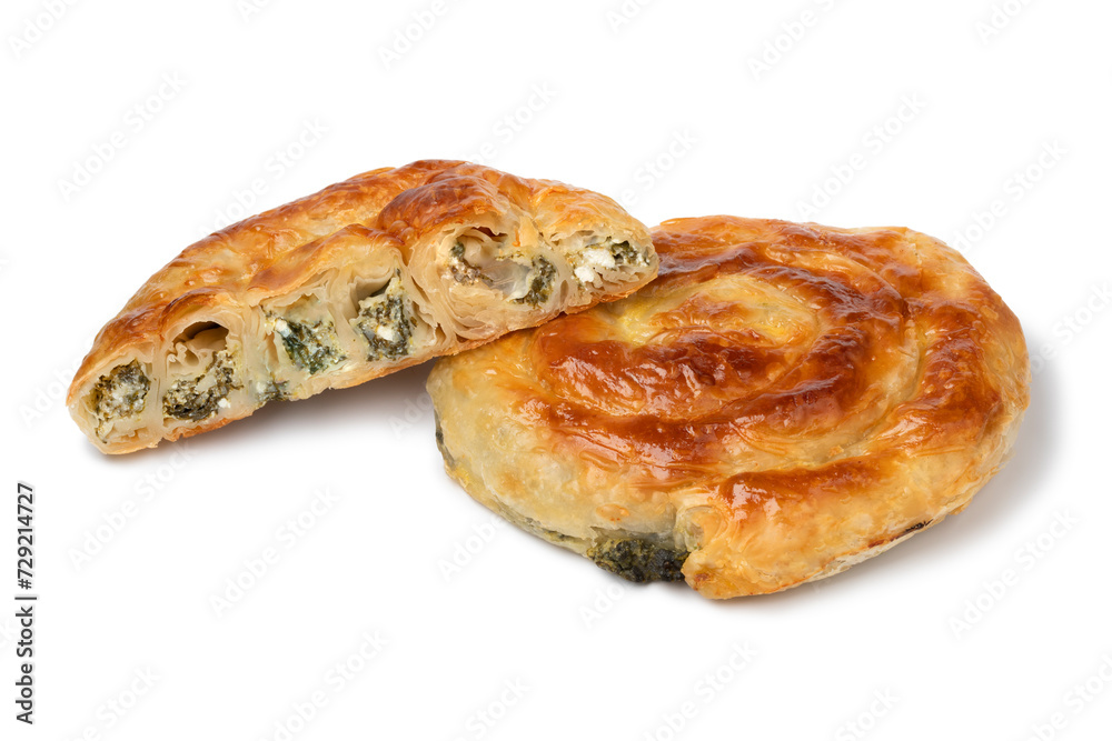 Whole and halved fresh baked Turkish borek with spinach and cheese close up isolated on white background Whole and halved fresh baked Turkish borek with spinach and cheese close up isolated on white background
