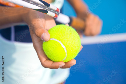 close-up of the hands of a female tennis player holding a tennis racket and a tennis ball  © Павел Мещеряков