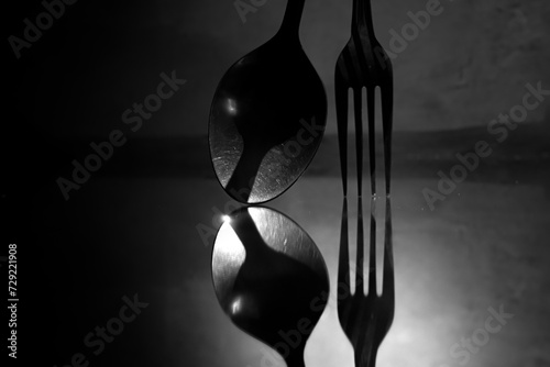 shadow or reflection of a spoon and fork standing on the floor photo