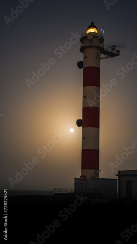 Abades lighthouse with the sea and the full moon