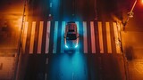 A car with its headlights on drives over a pedestrian crosswalk at night. Top view from drone.