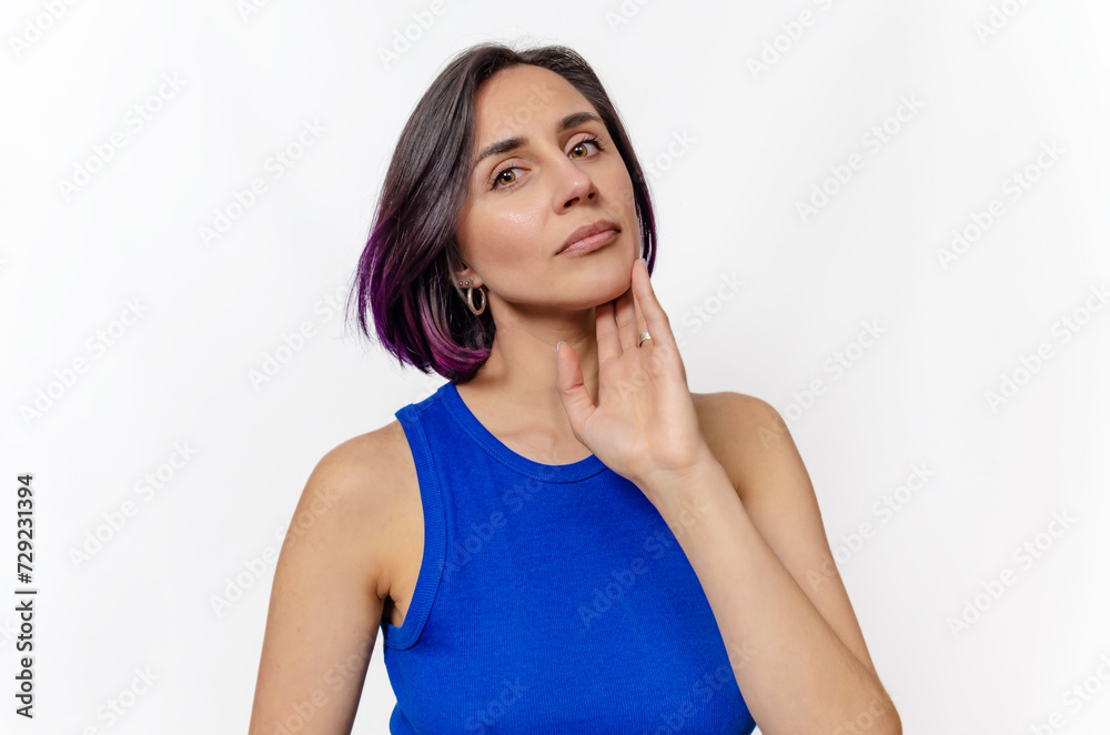 Dark-haired woman in blue dress posing in studio isolated on white background. Half-turn portrait. Dark-haired woman in blue dress posing in studio isolated on white background. Half-turn portrait.