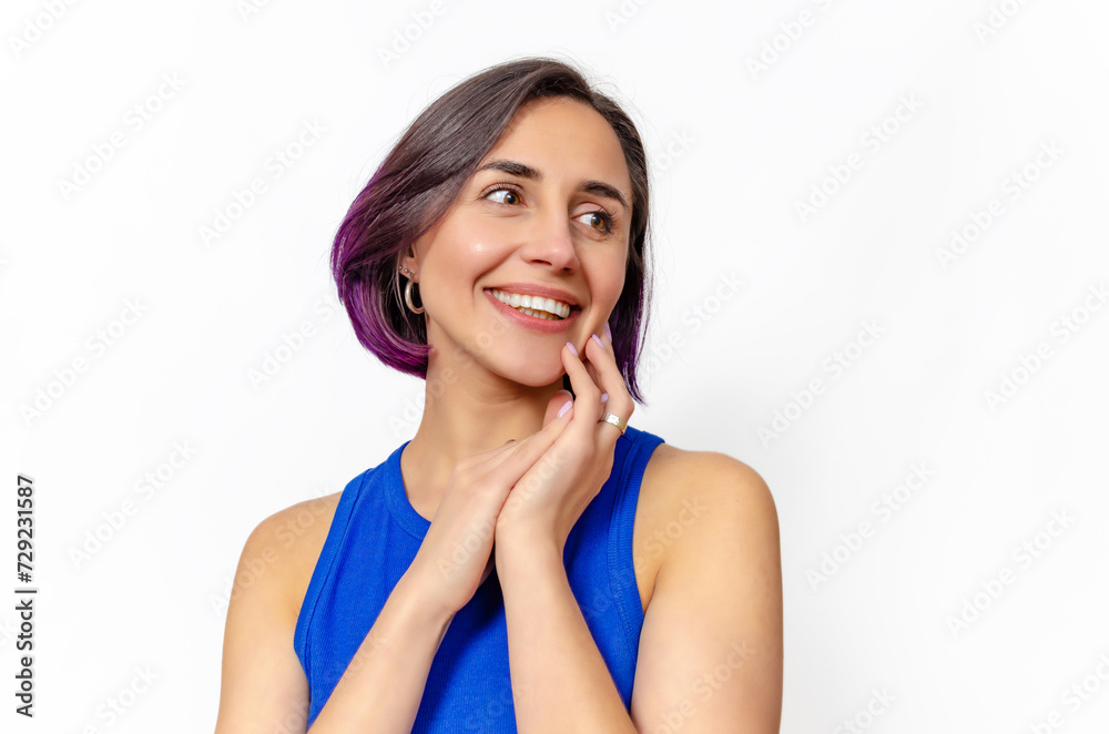 Dark-haired woman smiling with a big smile, showing perfect teeth. Hands near face. Looks to side. Dark-haired woman smiling with a big smile, showing perfect teeth. Hands near face. Looks to side.