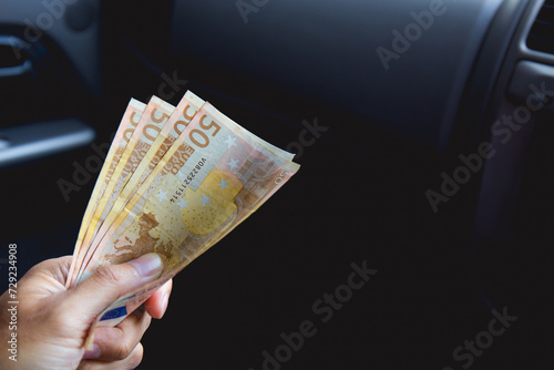 A male businessman pays taxi fare in euros with a tip for excellent service. Business concept.