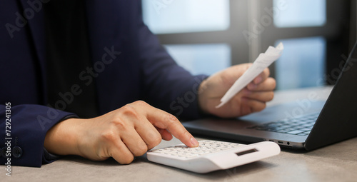 close up man hand press on calculator to check about debt bills pay monthly at the table in office and manage expense payroll for money risk and crisis financial concept photo