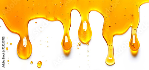 image of golden drops of honey flowing down on a white background; it can be used in food or cosmetic advertising