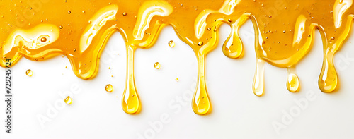 image of golden drops of honey flowing down on a white background; it can be used in food or cosmetic advertising