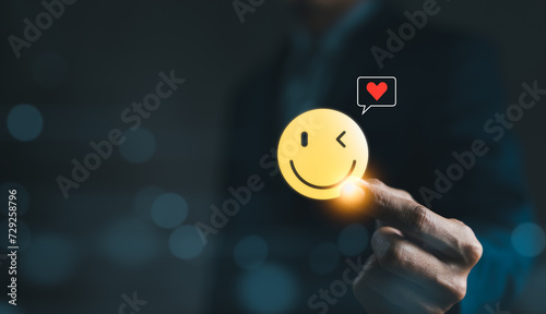 Mental Health Day concept. Hand holding a smiley face icon that depicts happy and giving a heart of love in the message box. positive thinking, Take care of your mental health, Customer satisfaction, photo