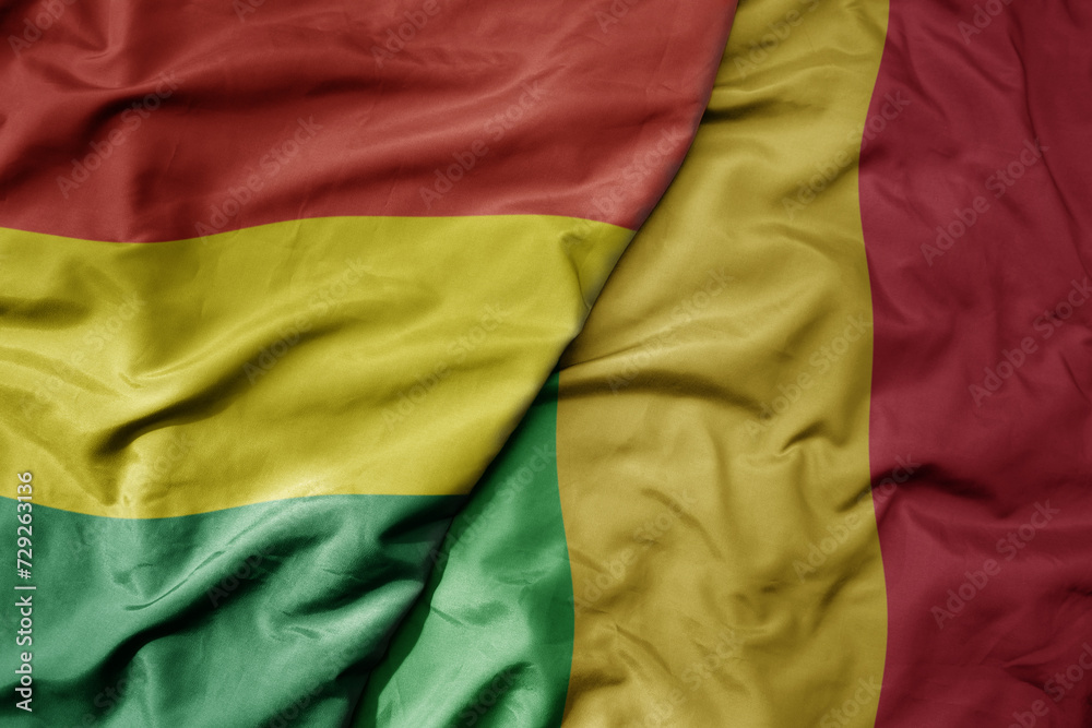 big waving national colorful flag of mali and national flag of bolivia .