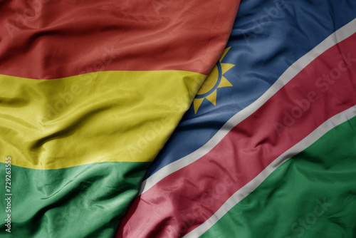 big waving national colorful flag of namibia and national flag of bolivia .