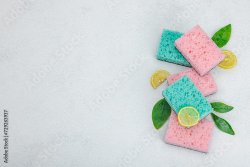 Various sponges for washing dishes. Organic cleaning concept, lemon freshness. Stone background