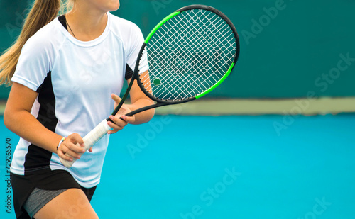 A girl plays tennis on a court with a hard blue surface on a summer sunny da © Павел Мещеряков