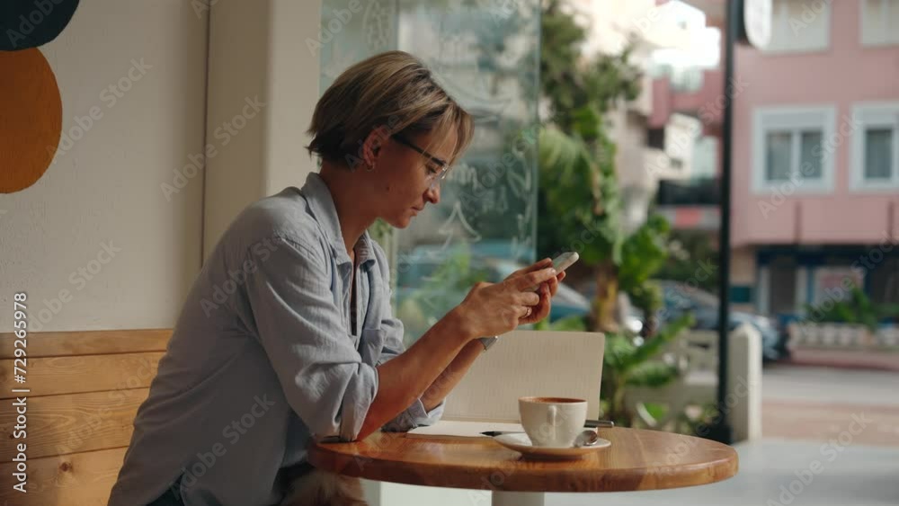 Business freelance woman using smartphone for browsing Internet, reading and texting while sitting on table in cafe. Lifestyle, working at coffee shop concepts. Social media. High quality 4k footage Business freelance woman using smartphone for browsing Internet, reading and texting while sitting on table in cafe. Lifestyle, working at coffee shop concepts. Social media. High quality 4k footage