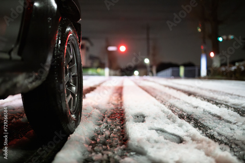 雪の積もった交差点と車のタイヤ