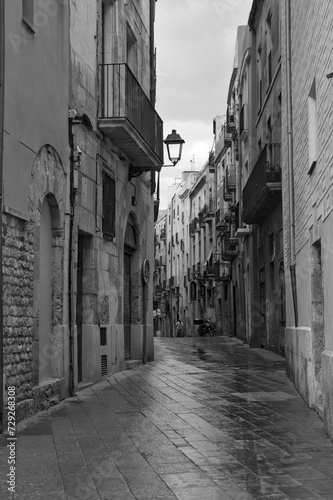 a narrow street with a lamp post and buildings