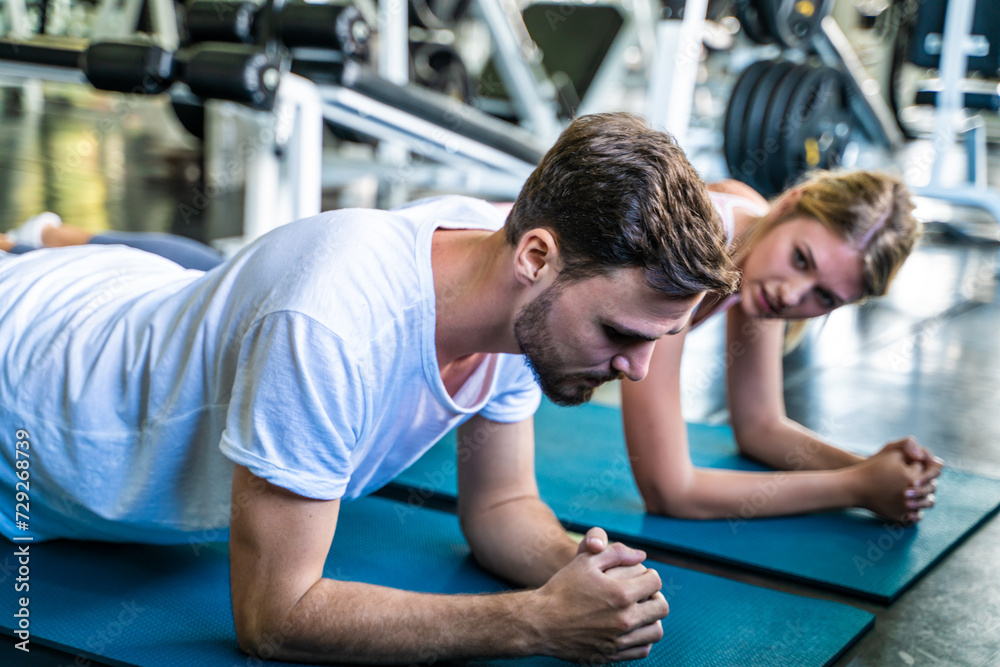 Sport active caucasian man and woman friend doing plank position indoor sport gym Sport active caucasian man and woman friend doing plank position indoor sport gym
