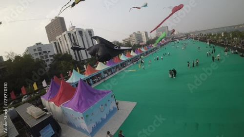 This captivating aerial footage showcases the vibrant spectacle of the International Kite Festival in Ahmedabad, India. The sky is adorned with a myriad of colorful kites of various shapes and sizes