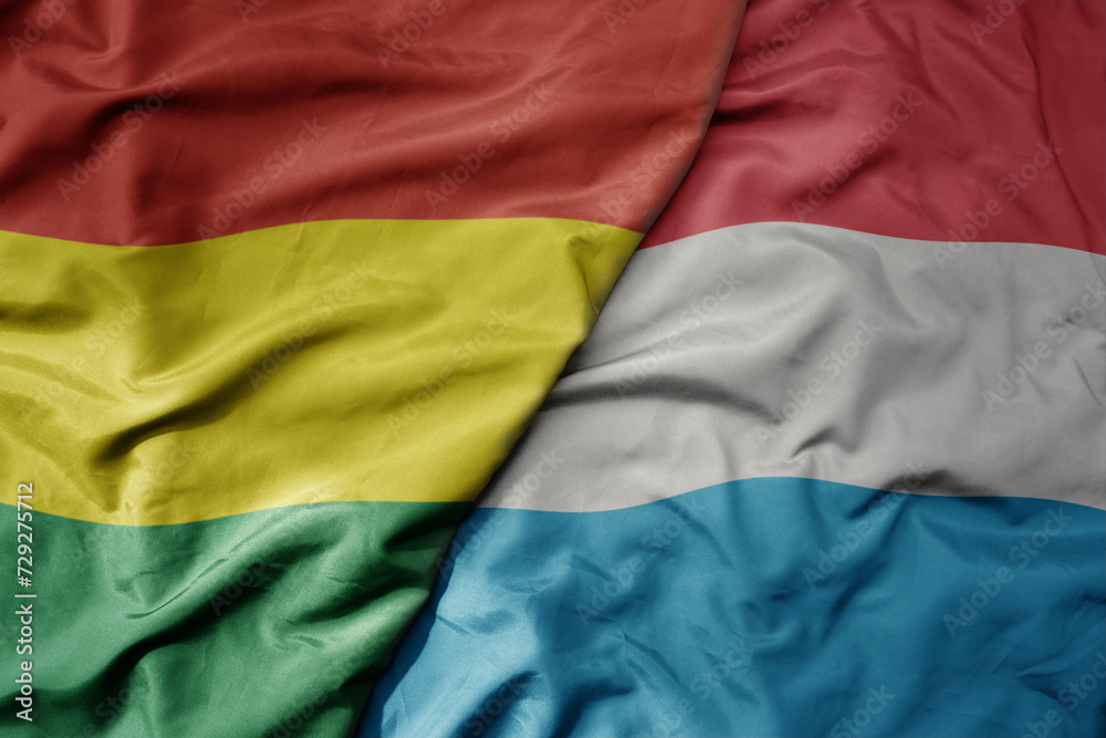big waving national colorful flag of luxembourg and national flag of bolivia . big waving national colorful flag of luxembourg and national flag of bolivia .
