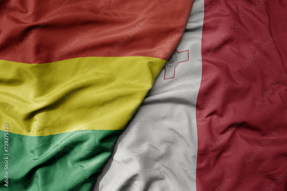 big waving national colorful flag of malta and national flag of bolivia .