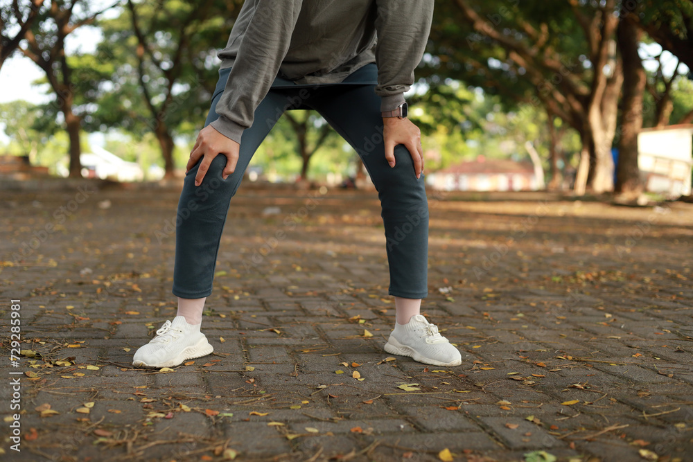 Obraz premium Cropped of asian woman tired, holding her legs, exhausted, taking a rest after running hard