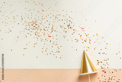 Confettis et chapeau pointu, les ingrédients pour un carnaval réussi. Fond blanc et rose saumon avec espace négatif pour texte pour le Carnaval de Nice, Dunkerque, Venise, Rio de Janeiro en février photo