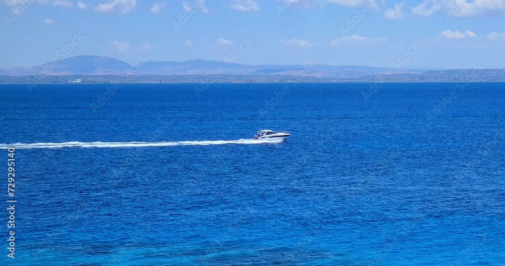 yacht speeds on a blue sea leaving a long white trail under a clear blue sky, concept of summer vacation yacht speeds on a blue sea leaving a long white trail under a clear blue sky, concept of summer vacation