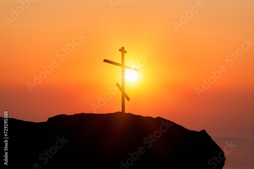 Shining cross on hill at sunset sky