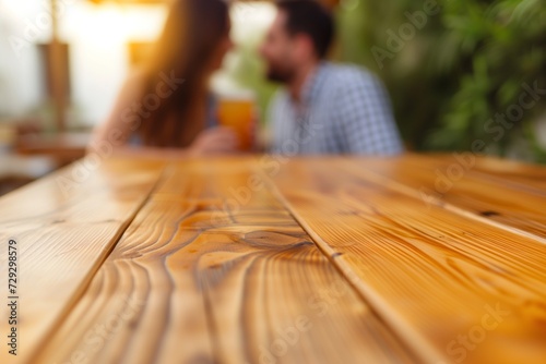 spotless wood table, blurred couple enjoying drinks behind