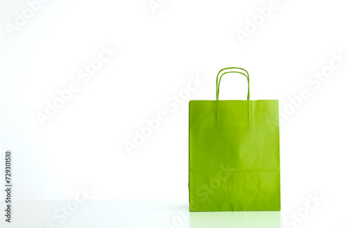 Empty bright apple green paper shopping or gift bag, isolated on white. No people